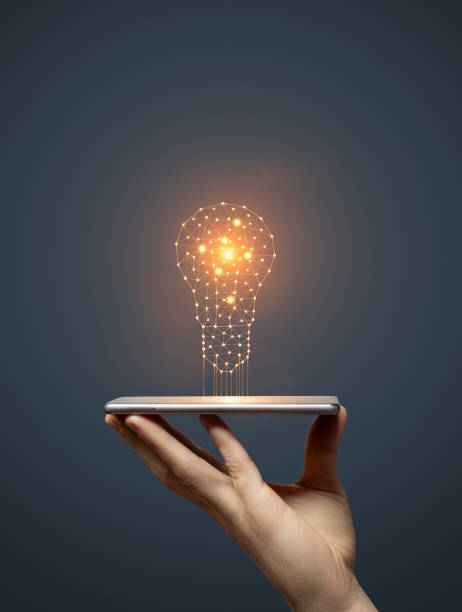 istock Idea concept with hand holding smartphone with glowing light bulb 1603136046