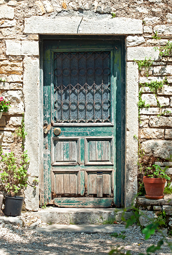 Ornate old door, Old Perithea, Island of Corfu, Greece. Corfu, or Korkyra, lies to the west of the Greek and Albanian mainland and separates the Adriatic from the Ionian Seas. Largely formed from Limestone, the island measuring some thirty miles by 18 miles is now a tourist destination, known for its beaches, climate and olives. Medieval castles and ancient ruins chart the military history of the island back to ancient Greek mythology.