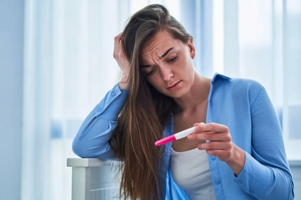 istock Sad upset unhappy woman holds pregnancy test 1603148224