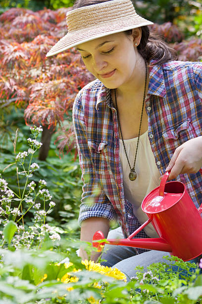 istock young woman with watering can 160314908