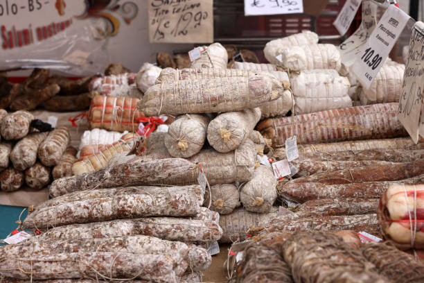 prodotti tradizionali a base di carne venduti in una bancarella di strada durante il mercato degli agricoltori a cremona, lombardia, italia - bresaola foto e immagini stock