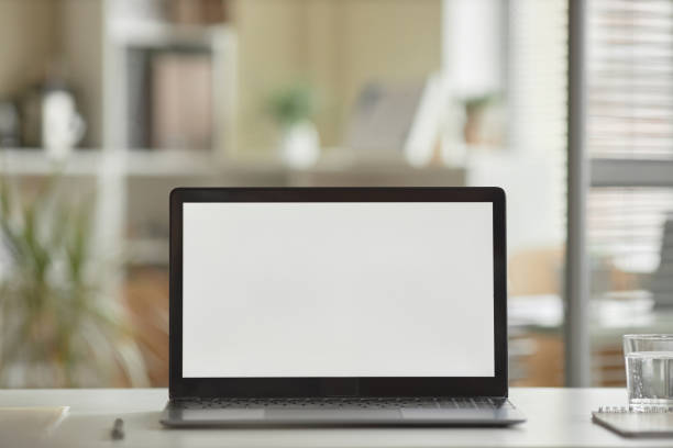 istock Closeup open laptop computer with blank white screen mock up on desk in office 1603179597