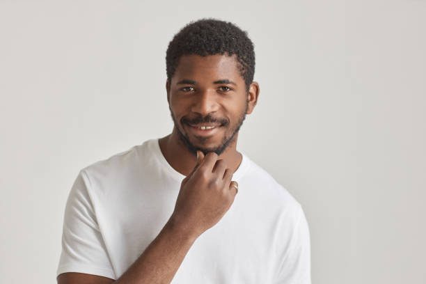 istock Handsome black man smiling at camera against white 1603179606