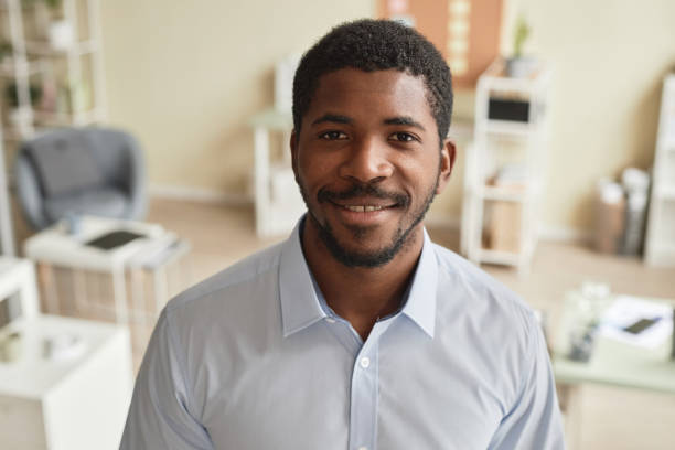 istock Front view closeup smiling black man standing in office and looking at camera 1603180136