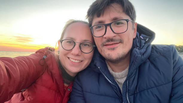 istock Couple makes selfie on smart phone over beautiful sunset on the beach 1603183946
