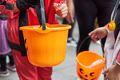 Children collecting candy on pumpking baskets at Halloween Trick or Treat event