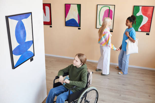 istock Boy with disability looking at abstract pictures in art gallery 1603192103