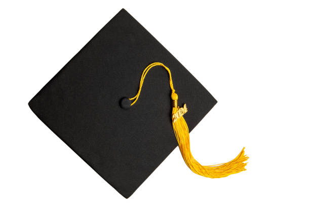 A class of 2024 charm on a yellow tassel on a black graduation cap, isolated on a white background.