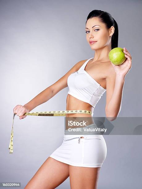 A Slimming Woman With A Measuring Tape And An Apple Stock Photo - Download Image Now