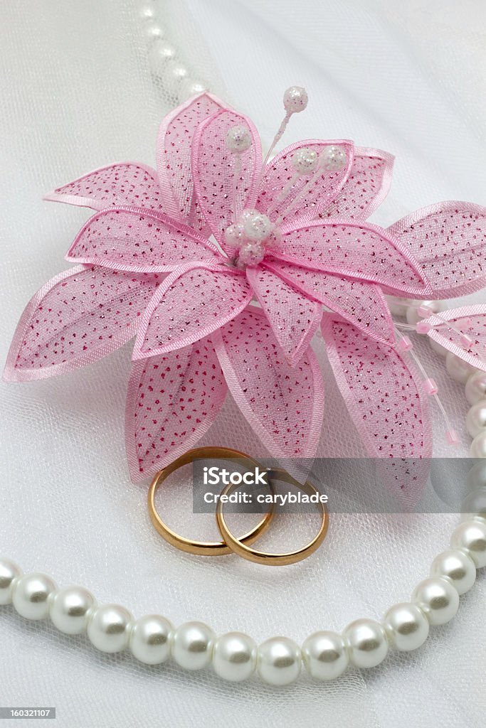 Fiori e due anelli d'oro su uno sfondo di matrimonio - Foto stock royalty-free di Amore