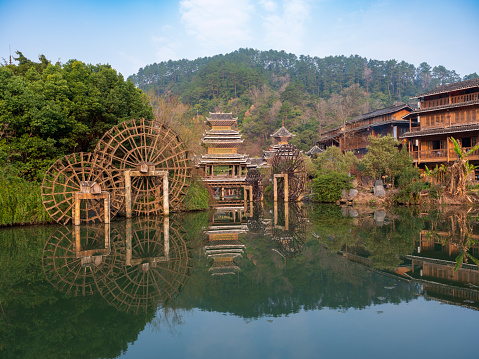 Waterwheel and Wind and Rain Bridge on the lake in Zhaoxing Dong Villages, Qiandongnan Miao and Dong Autonomous Prefecture, Guizhou, China.