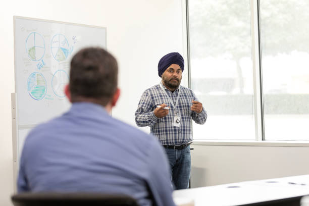 istock Male financial officer uses graphs on whiteboard to explain budget 1603237332