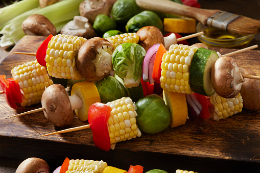 Preparing Vegetable Kebabs with Corn on the Cob, Yellow and Green Zucchini, Mushrooms, Red Onions and Red Peppers