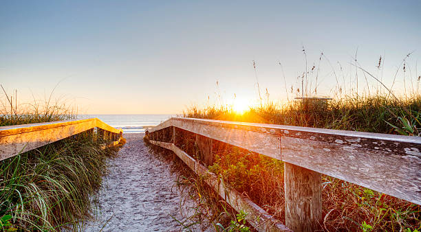 Sunset at Cocoa Beach, Florida Sunset at Cocoa Beach, Florida with Dunes, Boardwlak, and Sand. cocoa beach photos stock pictures, royalty-free photos & images