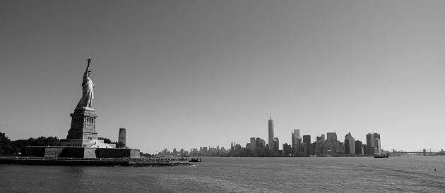 Statue of Liberty before the NYC skyline in black and white from away of Liberty Island