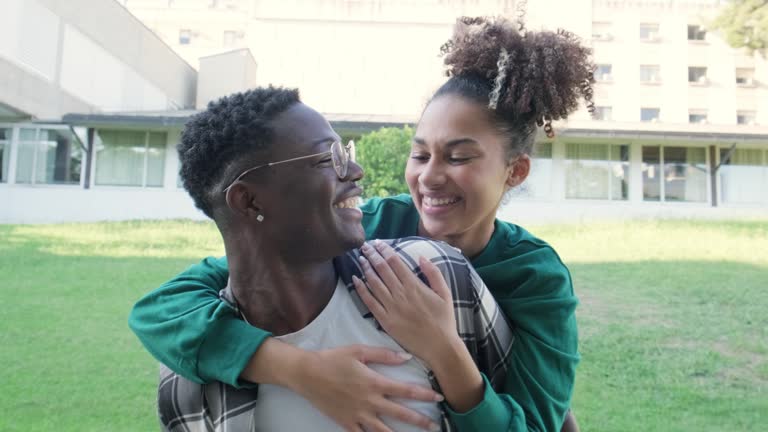 Young African America couple in love looking into each others eyes, Happy black man carrying girlfriend on the back.