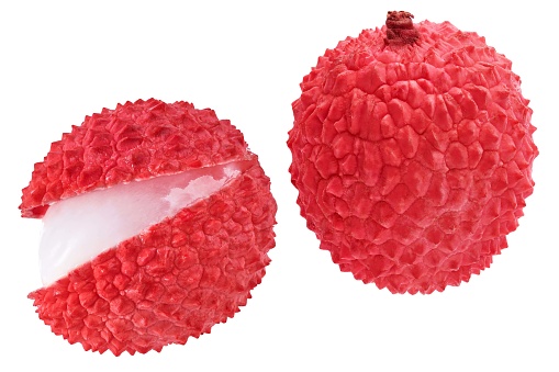 Peeled lychees and skinned lychees on a black chopping board