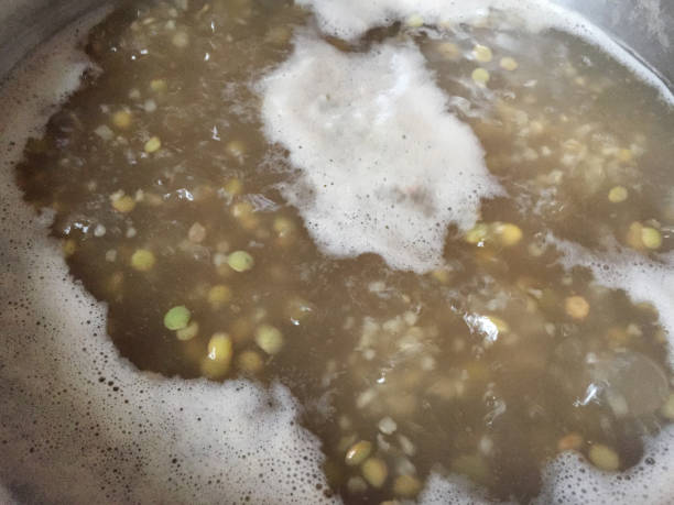 Green lentils cooking and boiling in a saucepan