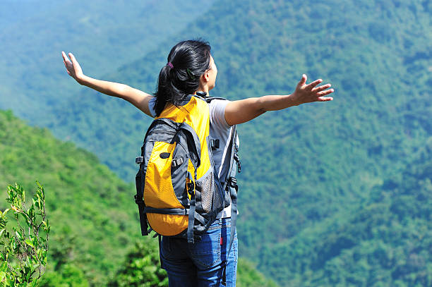 istock woman hiker stand mountain peak with arms open 160330032