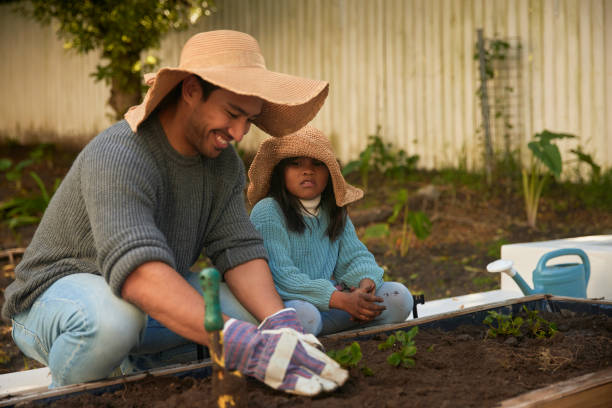 istock Real-Life Moments: A Father's Gardening Focus and a Daughter's Candid Discontent 1603307575