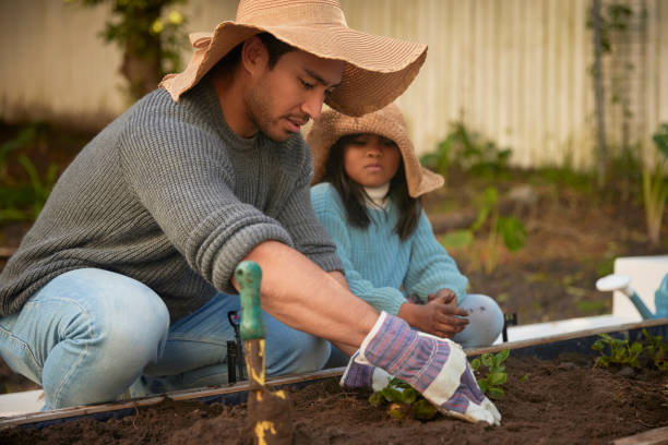 istock Real-Life Moments: A Father's Gardening Focus and a Daughter's Candid Discontent 1603307578