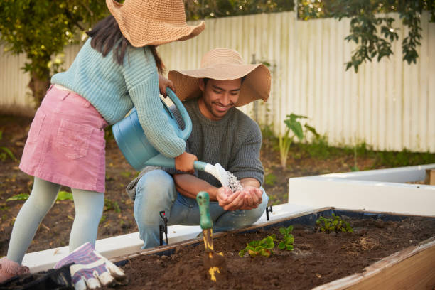 istock A Daughter's Helping Hands Nurturing a Seedling with Her Father 1603309152