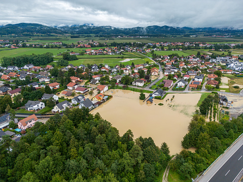 Extreme river flooding from a powerful storm - flooding houses, residential buildings, industrial zones, cars, roads and highways. Water destroying lives and everything in its way. Endless water damage in Slovenia, 2023. Aerial view of floods.