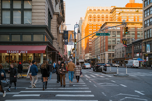 November 23, 2022 - New York, USA: View of Sixth Avenue, also known as Avenue of the Americas, a major thoroughfare in Manhattan that is commercial for much of its length. People walk in front.