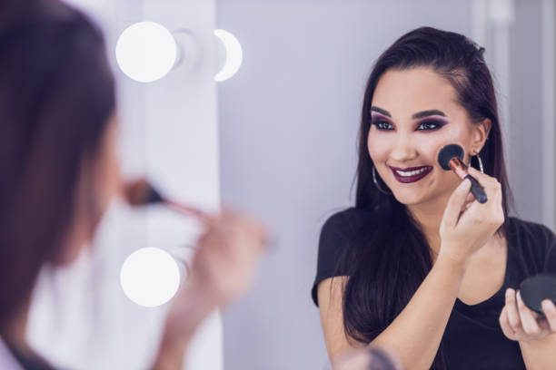 istock Woman Applying Blush In Front Of Mirror 1603322332