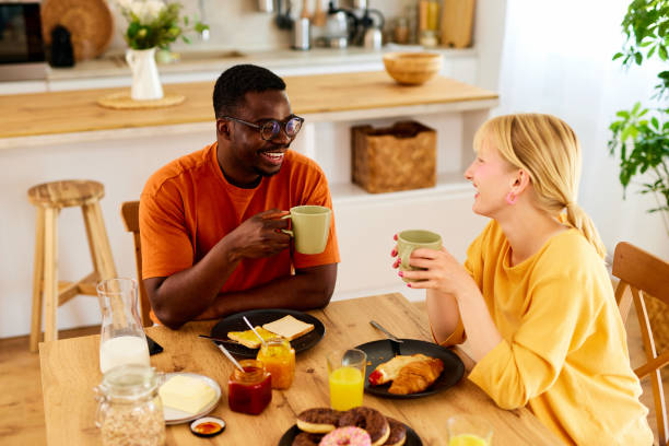 Multiracial couple enjoying breakfast together at home