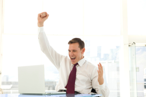 Front view / looking at camera / one person / waist up of 20-29 years old adult beautiful blond hair / long hair caucasian female / young women businesswoman / business person wearing businesswear / dress / a suit who is smiling / happy / cheerful / laughing / excited / successful and cheering / showing fist who is and doing fist pump