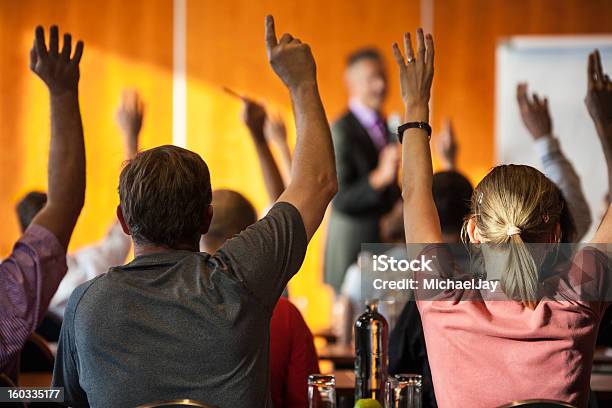 Meeting Attendees With Raised Hands In Foreground Stock Photo - Download Image Now - Voting, Hand Raised, Student