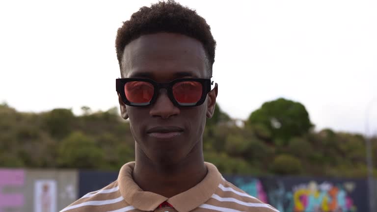 Young gay african man with make up looking on camera at LGBT pride parade