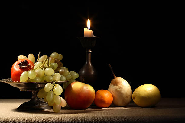 Fruits And Candle Vintage still life with fruits in bowl near lighting candle antique fruit bowl stock pictures, royalty-free photos & images