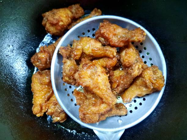 Fried Chicken in colander - food preparation.