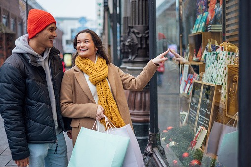 As they explore the bustling cityscape, the air is filled with laughter and anticipation, capturing the essence of youthful enthusiasm. This candid moment portrays a snapshot of love, connection, and the simple pleasures of the season. Their shared journey through the city center becomes a cherished memory, a testament to the magic that surrounds us during this special time of year.