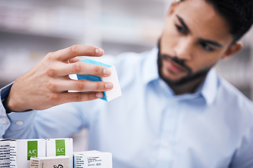 Pharmacy stock, man hand and drugs check of a customer in a healthcare and wellness store. Medical, retail inventory and pharmaceutical label information checking of a male person by a shop shelf