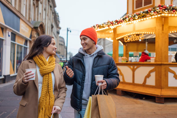istock Couple's Enchanting Christmas Shopping with Hot Chocolates 1603378391
