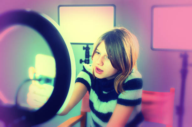 istock girl in striped sweater recording video content with ring light 1603385601