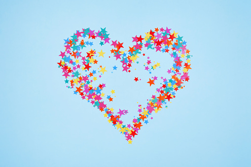 Heart shaped colorful stars on a blue background. Top view