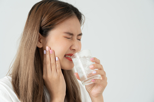 Asian woman feel sensitive teeth after drinking cold, female suffer tooth, decay problems, dental care, tooth extraction, decay problem, bad breath, Gingival Recession, Oral Hygiene instruction