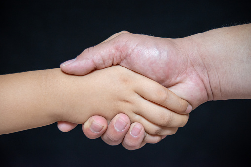 Child and Adult Shaking Hands，Child and Adult Shaking Hands，Concept of cooperation and success