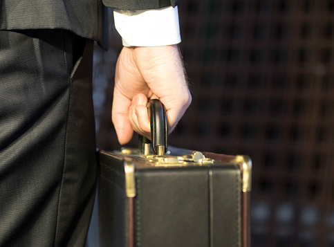 a person in a suit with a briefcase in hand