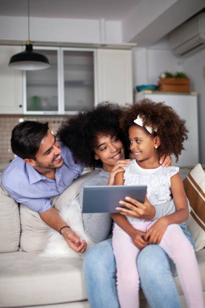 istock Happy family with their daughter enjoying using laptop computer together 1603409789