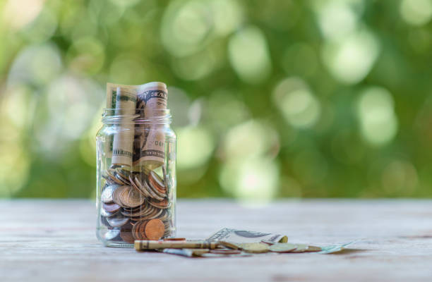 Jar filled with coins US bills