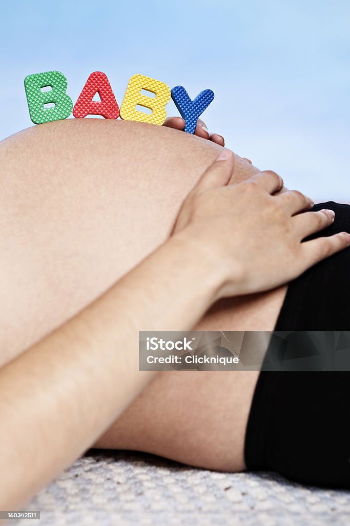 BABY-Buchstaben auf den schwangeren Bauch - Lizenzfrei 6-11 Monate Stock-Foto