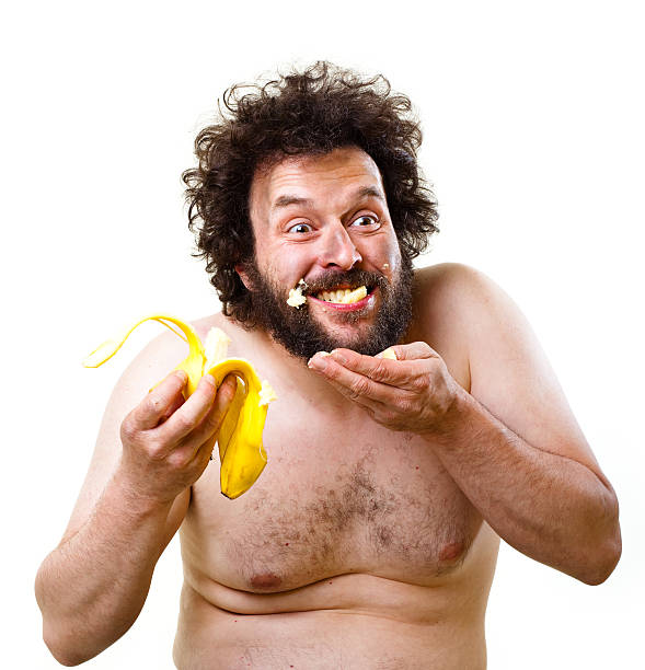 Caveman happy about having a banana to eat stock photo