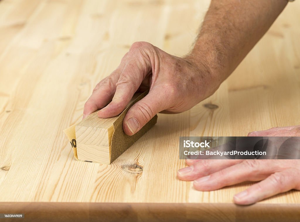 Mans manos en bloque de lijado con madera de pino - Foto de stock de Acabar libre de derechos