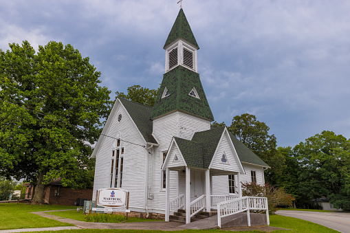 Wartburg, Tennessee, USA - July 29, 2023: Built in 1879 this pretty little historic church stands proud under cloudy skies.