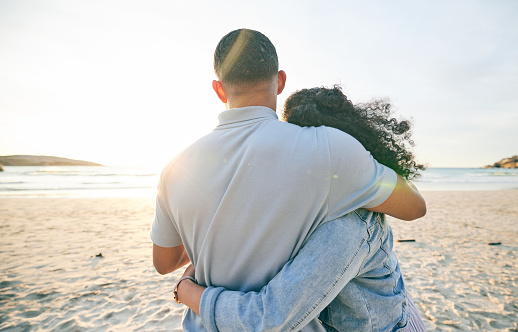 Couple hug, back and beach, ocean and travel with bond and love, trust and marriage outdoor. Adventure, tropical holiday and view of sea waves, man and woman with loyalty and life partner in nature